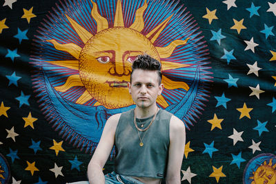 Portrait of young man with multi colored umbrella