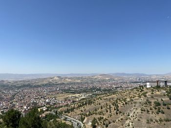 Aerial view of townscape against clear blue sky