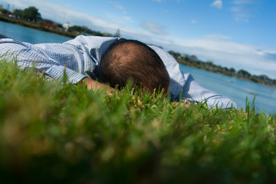 Surface level view of man lying on grassy field