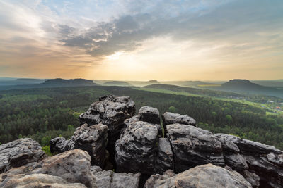 Rocks on land against sky during sunset