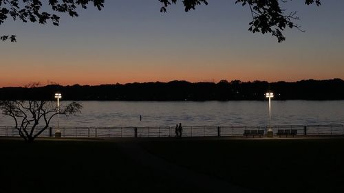 Scenic view of lake against clear sky during sunset