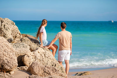 Rear view of woman standing at beach