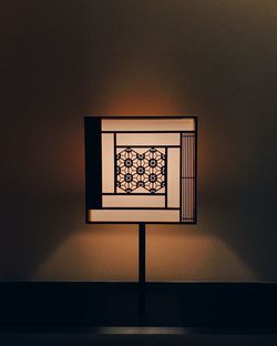 Illuminated lamp on wall at home