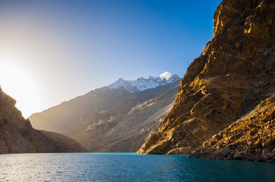 Scenic view of sea and mountains against clear sky