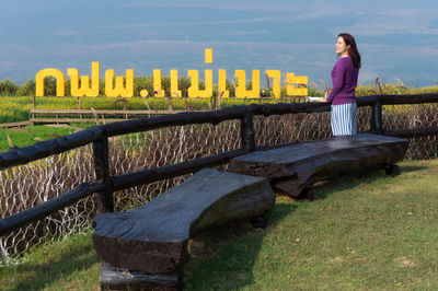 Woman sitting on railing