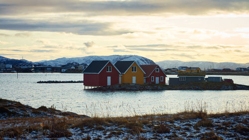 House by buildings against sky during winter