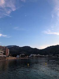 Scenic view of lake by buildings against sky