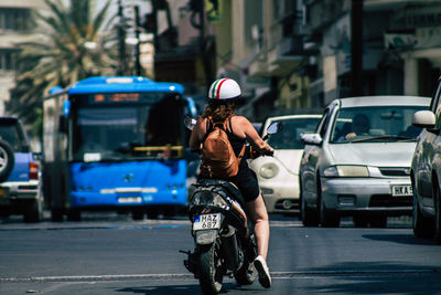 Rear view of woman with umbrella on street in city