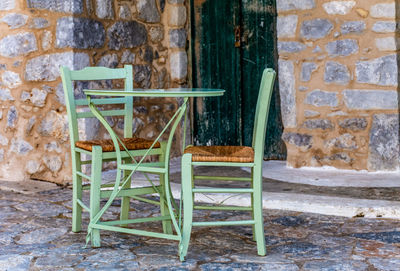 Empty chair against wall of old building