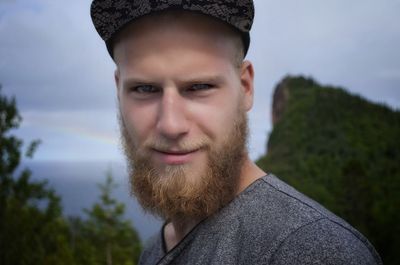 Portrait of smiling young man against trees