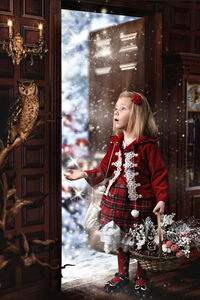 Girl with christmas decorations standing at entrance