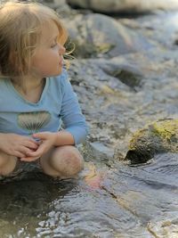 Side view of toddler girl pondering on  river