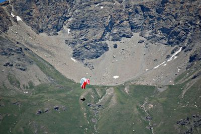 High angle view of person paragliding above mountains