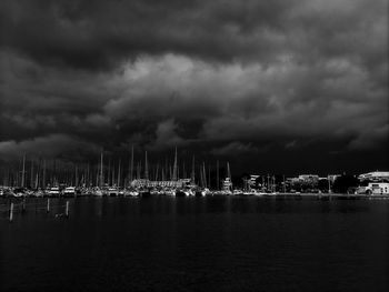 Sailboats in sea against cloudy sky