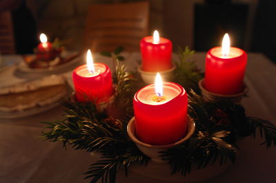 Close-up of illuminated tea light candles on table - advent wreath
