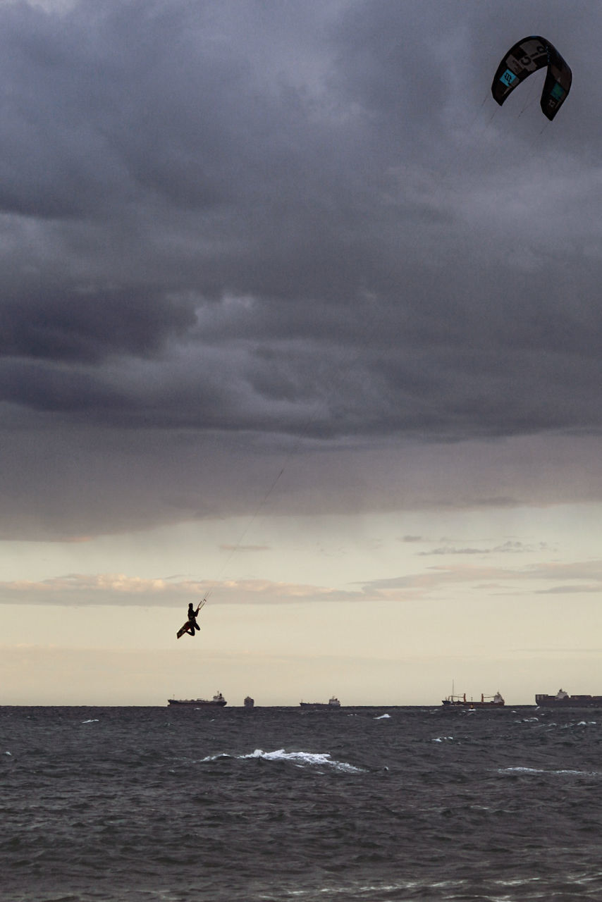 sky, water, cloud - sky, sea, flying, horizon, horizon over water, waterfront, scenics - nature, beauty in nature, nature, mid-air, sunset, adventure, motion, overcast, extreme sports, animal themes, outdoors, kiteboarding