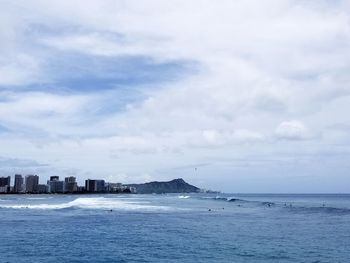 Scenic view of sea by buildings against sky