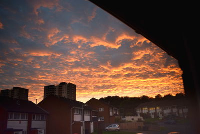 Exterior of city against dramatic sky during sunset