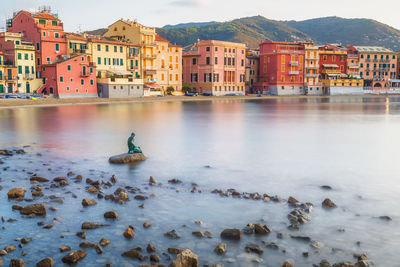 Scenic view of sea by buildings in city