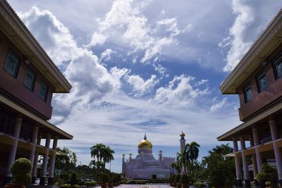 Buildings in city against cloudy sky