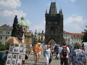 Group of people in front of buildings against sky in city