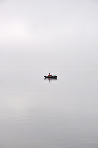 Boat sailing in lake against sky