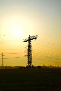 Scenic view of electricity pylon against sky during sunset