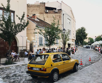 Vehicles on road by buildings in city