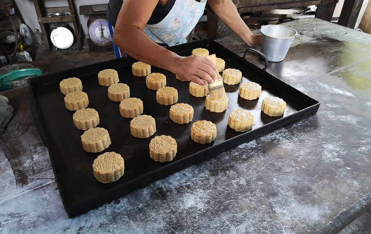 HIGH ANGLE VIEW OF PERSON PREPARING COOKIES