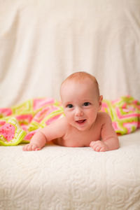 Portrait of cute baby lying on bed
