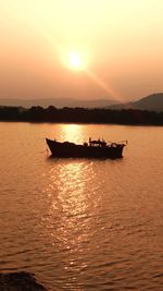 Silhouette boat in sea against sky during sunset