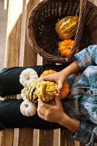 Midsection of person holding pumpkins