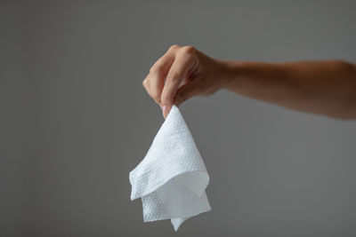 Close-up of hand holding umbrella against white background