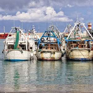 View of fishing boats and lighthouse in harbor