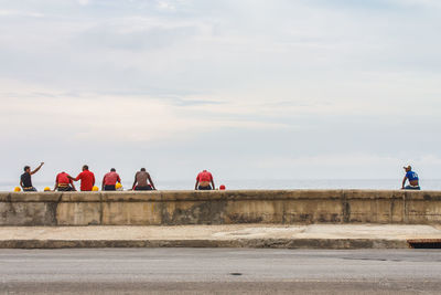 People by sea against sky