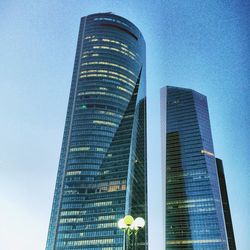 Low angle view of modern building against blue sky