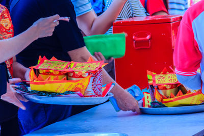 People buying religious offerings in plate