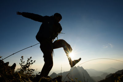 Low angle view of silhouette man playing against sky during sunset