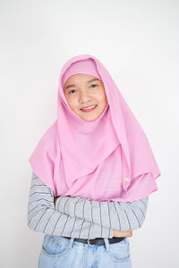 Portrait of a smiling young woman against white background