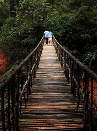 Footbridge amidst trees in forest
