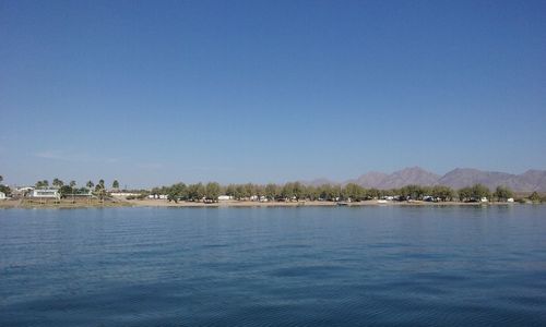 View of calm sea against clear blue sky