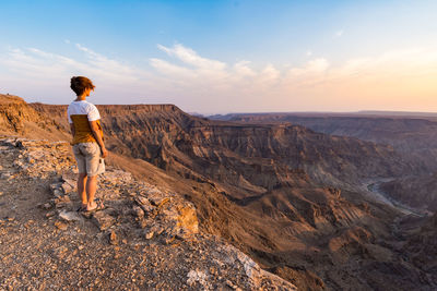 Woman standing on mountain against sky