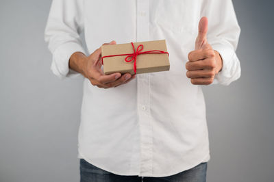 Midsection of man holding hands against white background