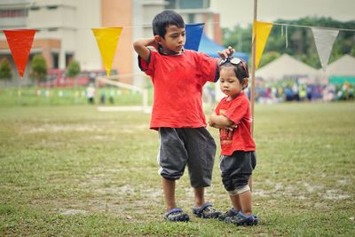 Full length of siblings standing on land