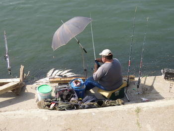 Rear view of man fishing in sea