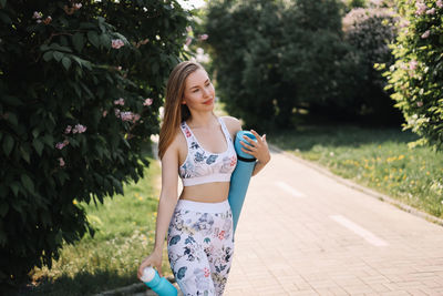 Athletic happy healthy young woman in sportswear goes after a sports workout exercise in nature