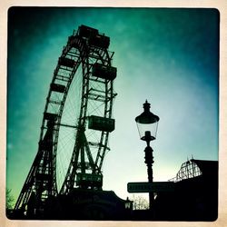 Low angle view of silhouette cranes against sky