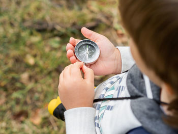 Midsection of boy holding compass