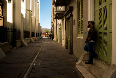 Man leaning on house in city