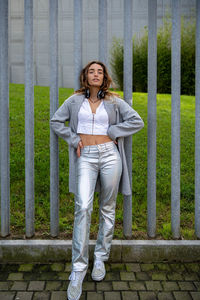 Portrait of young man standing against wall